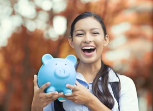 Close up of female holding blue piggy bank