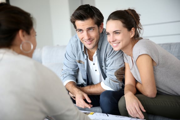 couple sitting down with financial advisor smiling